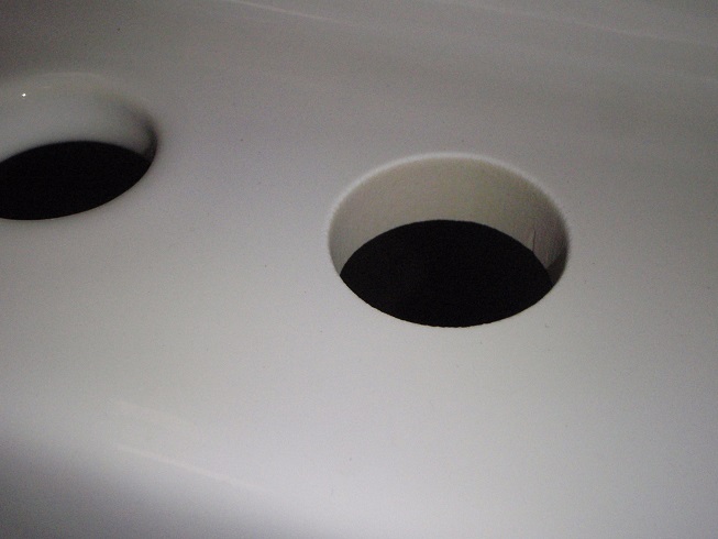 close up of a hole drilled into Bidet wtih watrerjet cutting